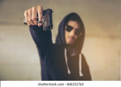 hooded-criminal-gesturing-gun-shootingspooky-260nw-606151763.jpg