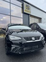 Black SEAT car outside dealership with signage in background.jpeg