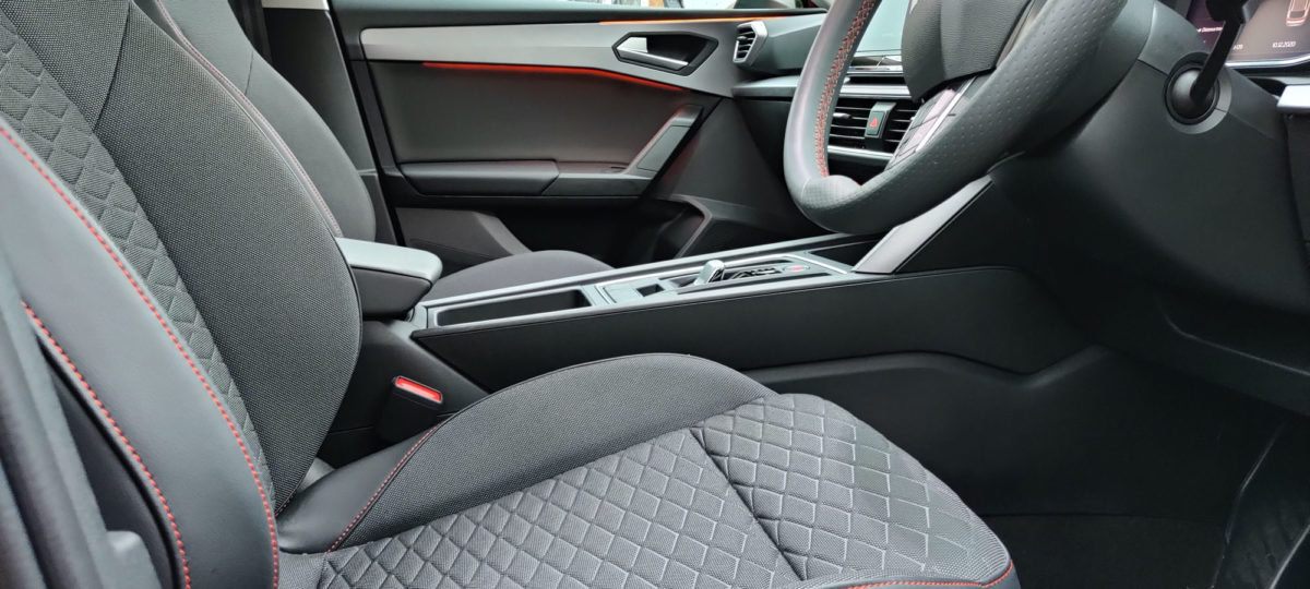 Seats with side bolsters and cross hatch material pattern with red stitching