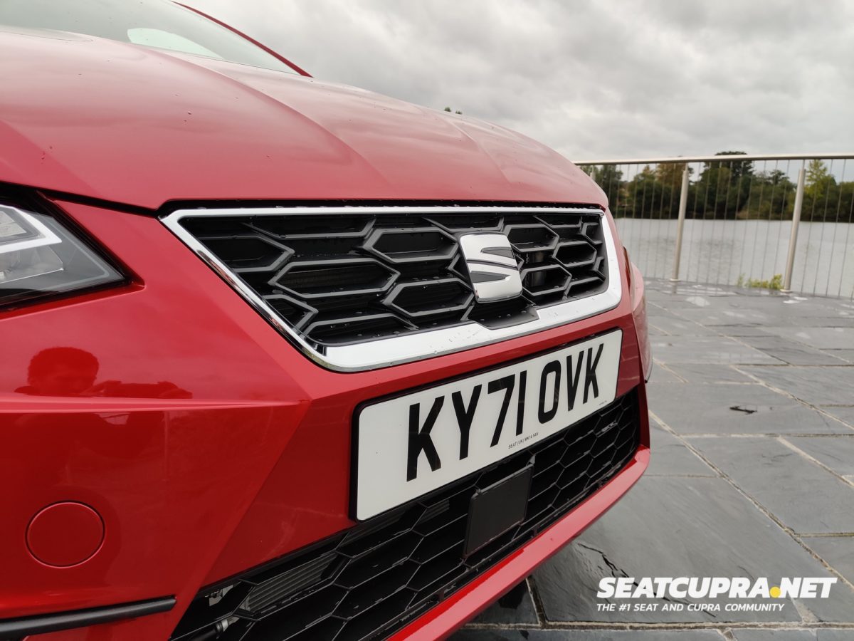 A close up of the Red SEAT Ibiza FR Sport front parked next to a lake