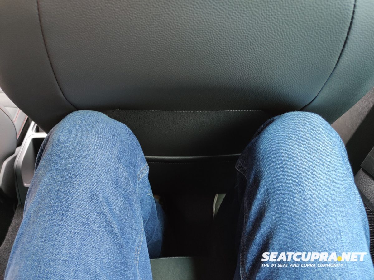 Looking down at the photographer's legs in jeans sat in the back seat showing the leg room.