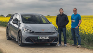 Scott and Mark stood in front of a grey CUPRA BORN and a field with yellow flowers