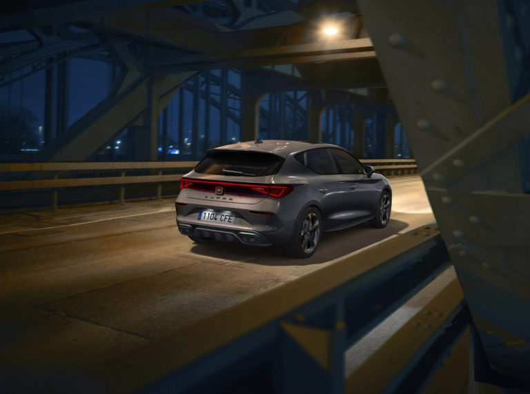 A grey CUPRA leon on a dark night crossing a bridge